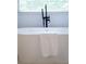 Close up of a modern bathtub with a black faucet and a white towel hanging on the side at 610 Woodstream Ct, Roswell, GA 30075