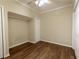 Bedroom features hardwood floors, a ceiling fan, and ample closet space for storage at 610 Woodstream Ct, Roswell, GA 30075
