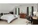 A well-lit bedroom features neutral colors, a wooden dresser, large windows, and a comfortable workstation at 610 Woodstream Ct, Roswell, GA 30075