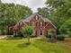 Charming brick home with black shutters, lush green lawn and beautifully landscaped front yard at 610 Woodstream Ct, Roswell, GA 30075