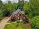 Classic brick home with manicured front lawn, mature trees, and charming curb appeal at 610 Woodstream Ct, Roswell, GA 30075