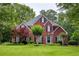 Charming two-story brick home with a lush green lawn and mature landscaping at 610 Woodstream Ct, Roswell, GA 30075
