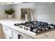 Close-up of the gas range in the kitchen with white subway tile backsplash at 610 Woodstream Ct, Roswell, GA 30075