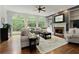 Spacious living room featuring a fireplace, built-in shelves, and large arched windows at 610 Woodstream Ct, Roswell, GA 30075