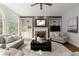 Living room featuring arched windows, a stone fireplace, built-in shelves, and hardwood floors at 610 Woodstream Ct, Roswell, GA 30075