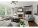 Bright living room with a fireplace, built-in shelving, and arched windows at 610 Woodstream Ct, Roswell, GA 30075