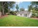 Secluded backyard with ample lawn space surrounded by trees and a wooden perimeter fence at 645 Ruxbury Ct, Suwanee, GA 30024