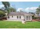 Backyard view features a large lawn and a classic white home design at 645 Ruxbury Ct, Suwanee, GA 30024