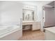 Bright bathroom featuring a soaking tub, tile floors, and a vanity with lots of counter space at 645 Ruxbury Ct, Suwanee, GA 30024