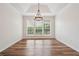 Dining room boasting wood floors, natural light, tray ceiling, and a stylish pendant light fixture at 645 Ruxbury Ct, Suwanee, GA 30024