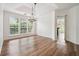 Dining room featuring wood floors, modern light fixture, crown molding, and natural light at 645 Ruxbury Ct, Suwanee, GA 30024