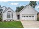 Charming one-story home with a two-car garage, brick exterior, and well-manicured lawn at 645 Ruxbury Ct, Suwanee, GA 30024