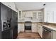 A kitchen featuring white cabinets, granite countertops, and stainless steel appliances, including a large, black refrigerator at 645 Ruxbury Ct, Suwanee, GA 30024