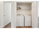 Convenient laundry closet featuring a washer, dryer, and built-in shelving for storage at 645 Ruxbury Ct, Suwanee, GA 30024