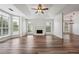 Spacious living room with a fireplace, ceiling fan, and plenty of natural light from large windows at 645 Ruxbury Ct, Suwanee, GA 30024