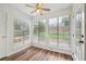 Bright sunroom with large windows overlooking the backyard, featuring wood-look flooring and a ceiling fan at 645 Ruxbury Ct, Suwanee, GA 30024