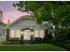 Charming brick home with arched entryway, large windows, and lush landscaping at dusk at 16 Walker Ne Ter, Atlanta, GA 30309