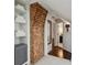 Hallway with exposed brick feature wall, shelving, and doorway to bathroom, creating a cozy, classic aesthetic at 16 Walker Ne Ter, Atlanta, GA 30309