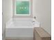 Modern bathtub with white tiling and a frosted glass window at 397 Cypher Dr, Suwanee, GA 30024