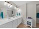 Bathroom with double sink vanity, tiled floor, and large mirror at 397 Cypher Dr, Suwanee, GA 30024