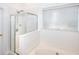 Clean bathroom featuring a shower, tub, tile floors, and a large window at 630 Beckenham Walk Dr, Dacula, GA 30019