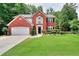 Charming two-story brick home with a well-manicured lawn and an attached two-car garage at 630 Beckenham Walk Dr, Dacula, GA 30019