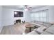 Spacious living room with a fireplace, large TV, hardwood floors, and a modern sofa at 630 Beckenham Walk Dr, Dacula, GA 30019