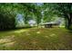 Large grassy backyard with mature trees and an inviting screened-in porch for outdoor relaxation at 6516 Maddox Rd, Morrow, GA 30260
