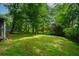 A sprawling, lush backyard with mature shade trees and vibrant green grass at 6516 Maddox Rd, Morrow, GA 30260