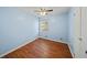 This cozy bedroom has hardwood floors, light blue walls, a ceiling fan, and one window at 6516 Maddox Rd, Morrow, GA 30260
