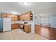 An eat-in kitchen with stainless steel appliances, wood cabinets, and tile floors overlooks the living area at 6516 Maddox Rd, Morrow, GA 30260
