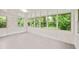 Sunroom with white wood plank flooring and windows showing the wooded area at 752 Jefferson Sw Ave, Atlanta, GA 30315