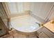 This bathroom features a large soaking tub with decorative tile surround and window with plantation shutters at 1315 Mcgill Park Ne Ave, Atlanta, GA 30312