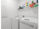 Bright laundry room features modern, front-load washer and dryer with shelf for storage at 1534 Bedstone Dr, Canton, GA 30114
