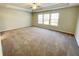 Spacious main bedroom featuring a ceiling fan, carpet flooring and lots of natural light from multiple windows at 2314 Shetley Creek Dr, Norcross, GA 30071