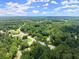 The property's location is shown in this aerial shot surrounded by winding roads and abundant trees at 1467 Hewatt Rd, Lilburn, GA 30047