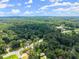 Expansive aerial shot shows the property's location surrounded by lush greenery and mature trees at 1467 Hewatt Rd, Lilburn, GA 30047
