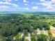 An aerial view showing the neighborhood and property surrounded by lush, green trees at 1467 Hewatt Rd, Lilburn, GA 30047
