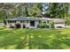 Charming one-story home with a manicured lawn, grey siding, and mature landscaping at 1467 Hewatt Rd, Lilburn, GA 30047