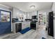 Updated kitchen with grey cabinets, black appliances, and dark blue backsplash at 1467 Hewatt Rd, Lilburn, GA 30047