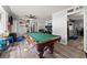 Bright and airy recreation room with a pool table, adjacent to a dining area with modern design at 1467 Hewatt Rd, Lilburn, GA 30047