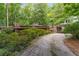 Stone and wood home with flat roof design and mature trees along driveway at 2016 Castleway Ne Dr, Atlanta, GA 30345