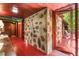 Hallway with stone accent wall, wood paneled ceilings, and red floors leading to outdoor porch area at 2016 Castleway Ne Dr, Atlanta, GA 30345