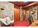Hallway featuring unique stone walls, wood ceilings, and red floors with access to rooms and closets at 2016 Castleway Ne Dr, Atlanta, GA 30345