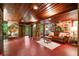 Spacious living room featuring stone walls, wood ceilings, concrete floors, and access to outdoor living areas at 2016 Castleway Ne Dr, Atlanta, GA 30345