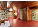 Cozy living room featuring unique stone walls, a wood-paneled ceiling, and red concrete floors with access to stairs at 2016 Castleway Ne Dr, Atlanta, GA 30345