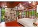 Bright main bedroom with exposed stone accent wall, wood ceiling, and access to a private balcony at 2016 Castleway Ne Dr, Atlanta, GA 30345