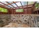 Unique sunroom with stone and concrete structure, wood framing, and translucent ceiling at 2016 Castleway Ne Dr, Atlanta, GA 30345