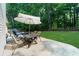 View of the backyard patio, featuring a dining table with seating and an umbrella at 7610 Golden Sands Dr, Cumming, GA 30041