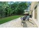 View of the back yard from the patio, featuring mature trees, a well-manicured lawn, and a wooded fence line at 7610 Golden Sands Dr, Cumming, GA 30041